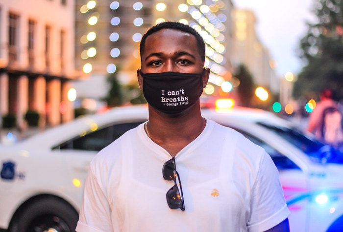 30 May 2020. Solomon from Virginia stands in front of a police car wearing a face mask with George F loyd's last words at the Black Lives Matter march for George Floyd in Washington DC, near the White House. Autor: Dee Dwyer