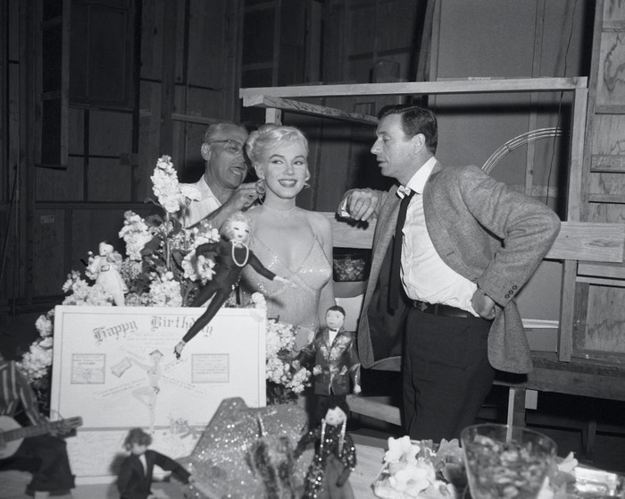 Režisér George Cukor a francouzský herec Yves Montand na oslavě 34. narozenin Marilyn Monroe, 1960         Autor: Getty Images