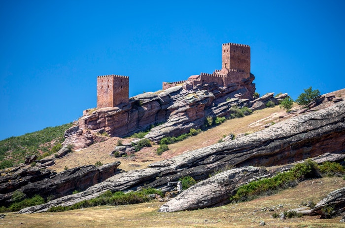  Hrad Zafra, Guadalajara, Španělsko: Tento středověký hrad postavený na pískovcovém výběžku má výhled na izolovaný úsek Sierra de Caldereros. Silný dojem udělá v šesté řadě jako Věž radosti, záhadná pevnost, která skrývá s napětím očekávané tajemství Jonova původu. Autor: Dukas/UIG via Getty Images