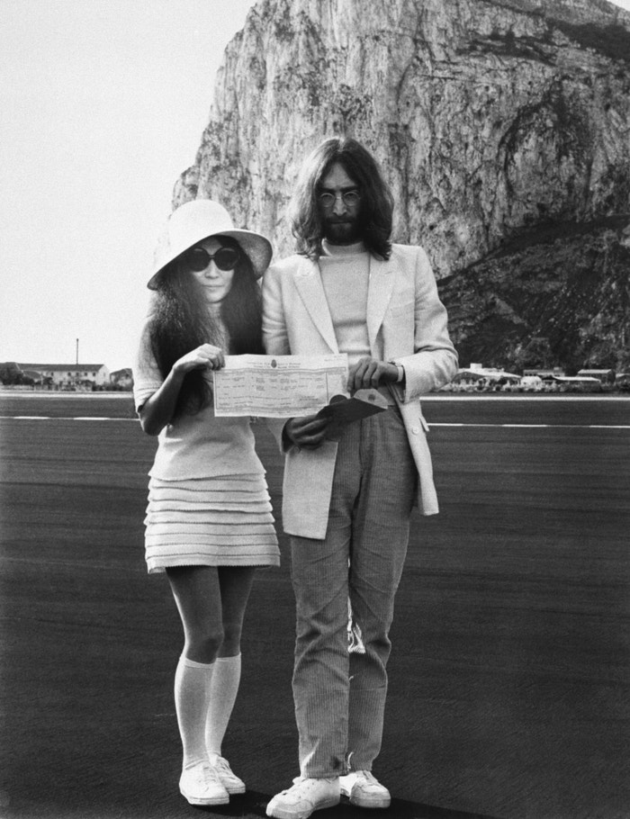 John Lennon a Yoko Ono drží na snímku oddací list krátce po svatebním obřadu, 21. března 1969. Brali se na Gibraltaru –⁠⁠⁠⁠⁠⁠ a stejně jako oba manželé –⁠⁠⁠⁠⁠⁠ i jejich look byly nekonvenční. Ono má na sobě dokonalý odraz dobových trendů: áčkovou minisukni s podkolenkami. Pokud hledáte styl, který je jedním dechem dívčí a zároveň boří tradice, pak vám právě Yoko Ono může být skvělou inspirací.