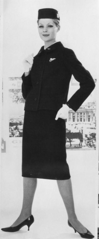 V roce 1960 byli studenti na Royal College of Art v Londýně požádáni, aby předložili návrh nové uniformy pro British European Airways (BEA). V porotě provádějící konečný výběr usedl i John Cavanagh, jeden z nejvýznamnějších představitelů britského módního průmyslu. Autorkou vybraného návrhu byla studentka Sylvia Ayton, která v roce 1964 uzavřela partnerství se Zandrou Rhodes a otevřela si v Londýně butik. Vybraný design byl vyroben z nového materiálu – čisté česané příze s malými modročernými kostkami s černým okrajem. Rovná sukně má vzadu plisování v diorovském stylu, kabátek je také plisovaný. Elegantní klobouček je ze stejného materiálu – byl navržen pro snadné balení. Autor: archiv British Airways