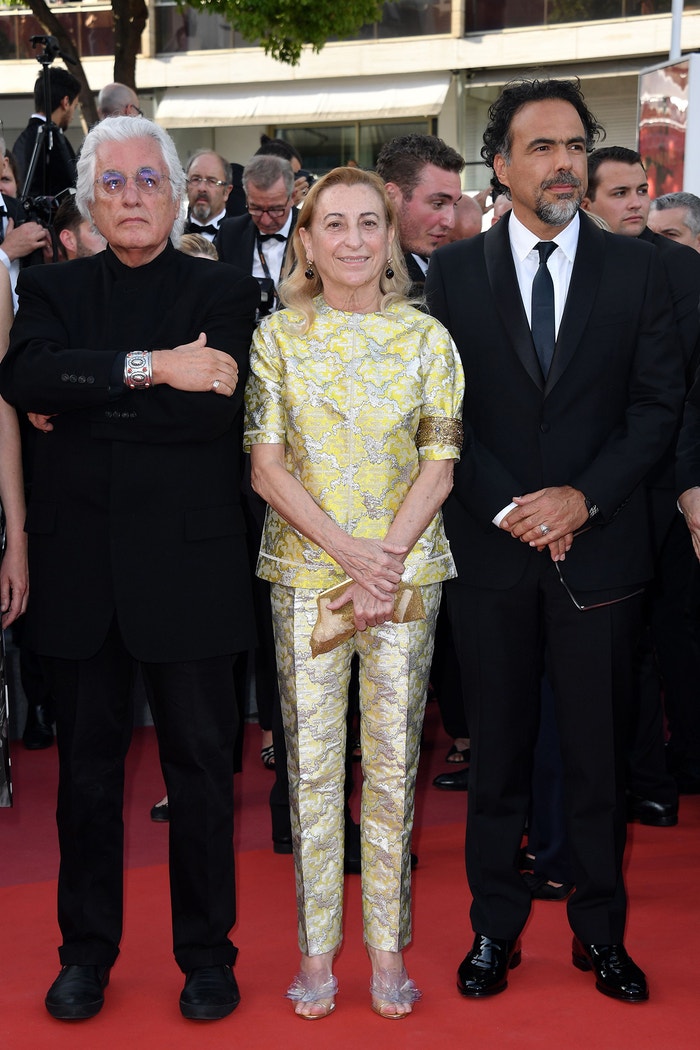 Metalické barvy, květen 2017. Červený koberec na filmovém festivalu v Cannes a Miuccia ukazuje metalický kalhotový kostým, ke kterému patří namísto saka luxusní top. Všimněte si (opět) náramku na rukávu a květinových aplikací na botách Miu Miu. Autor: Maria Laura Antonelli/Shutterstock/REX