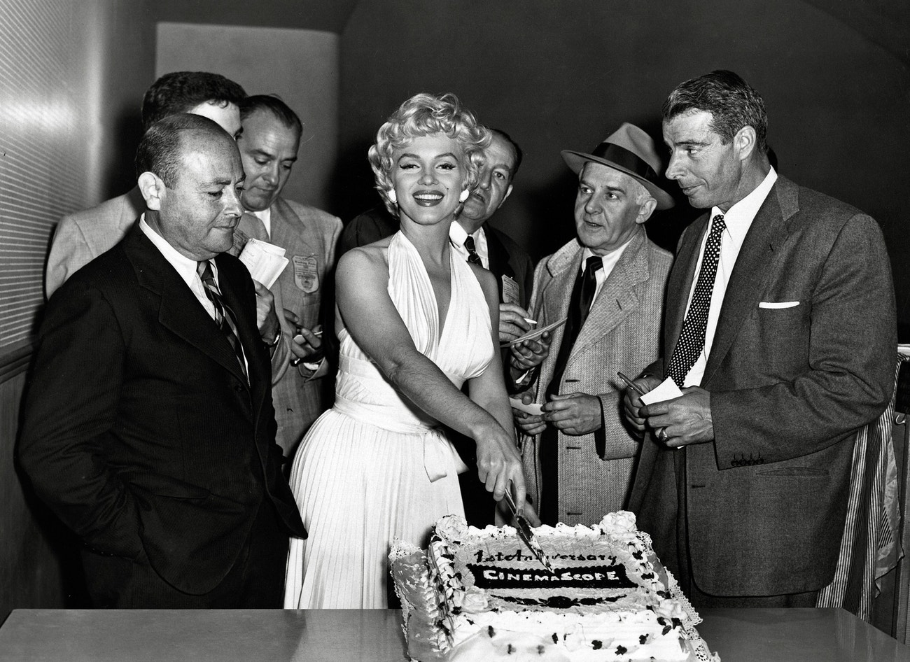 Marilyn Monroe při natáčení filmu Slaměný vdovec. Vpravo stojí její manžel Joe DiMaggio, 1954