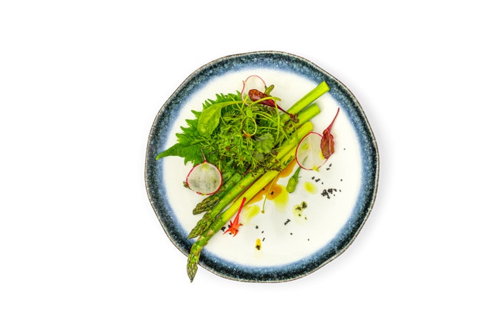 Pomalu vařený chřest připravený metodou sous vide s máslem, poté lehce ogrilovaný na lávovém grilu. Podává se s dresinkem z japonské máty a zahradním salátem. Autor: Archiv Buddha-Baru