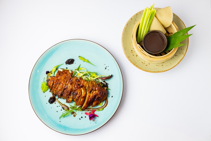 Pekingská kachna je před pečením glazovaná s hoisin omáčkou, aby kůže zůstala co nejkřupavější. Podává se s mandarínskými palačinkami potřenými sezamovým olejem, čerstvou okurkou, jarní cibulkou, pórkem a domácí hoisin omáčkou, která se dělá z fermentovaných sojových bobů.