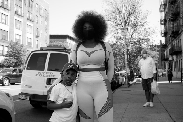 30 May 2020. A mother and son watch protesters in Brooklyn, New York.