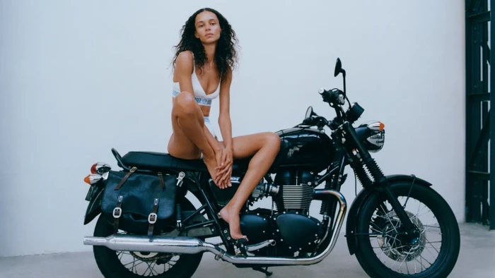 Binx Walton – spoře oděná a sedící na motorce – jak ji vidí Stef Mitchell